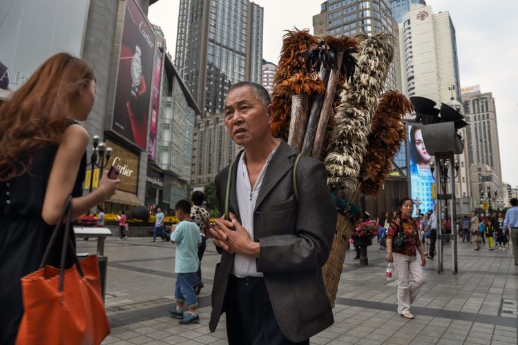 Бывший житель деревни продает метелки для пыли из куриных перьев в одном из городов Китая.